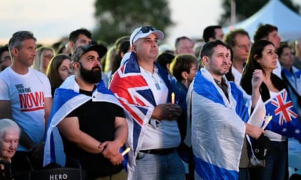 A crowd looks on at a Jewish community vigil